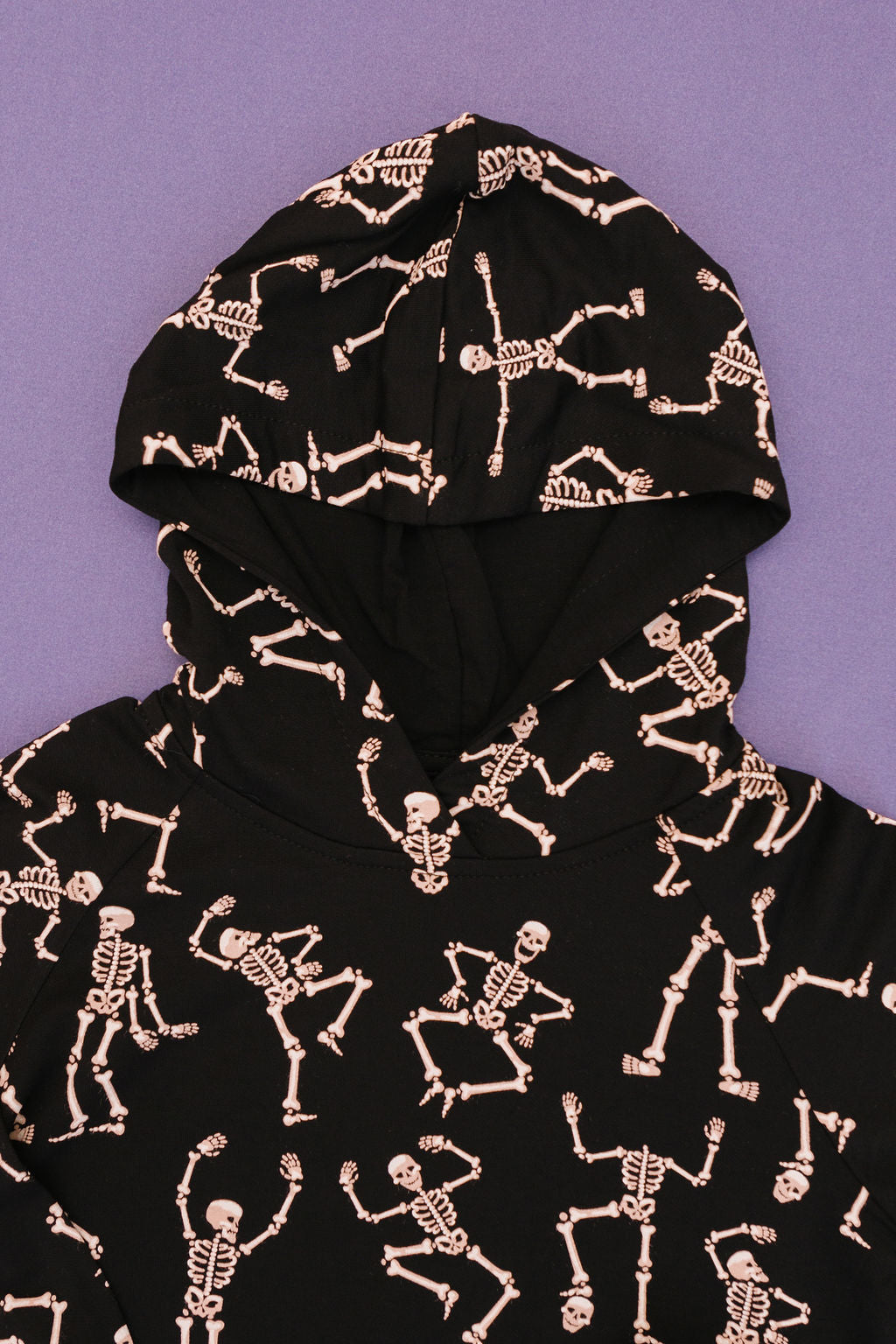 showing hood of Kids bamboo jogger set in black Dancing Skelly’s skeleton print.