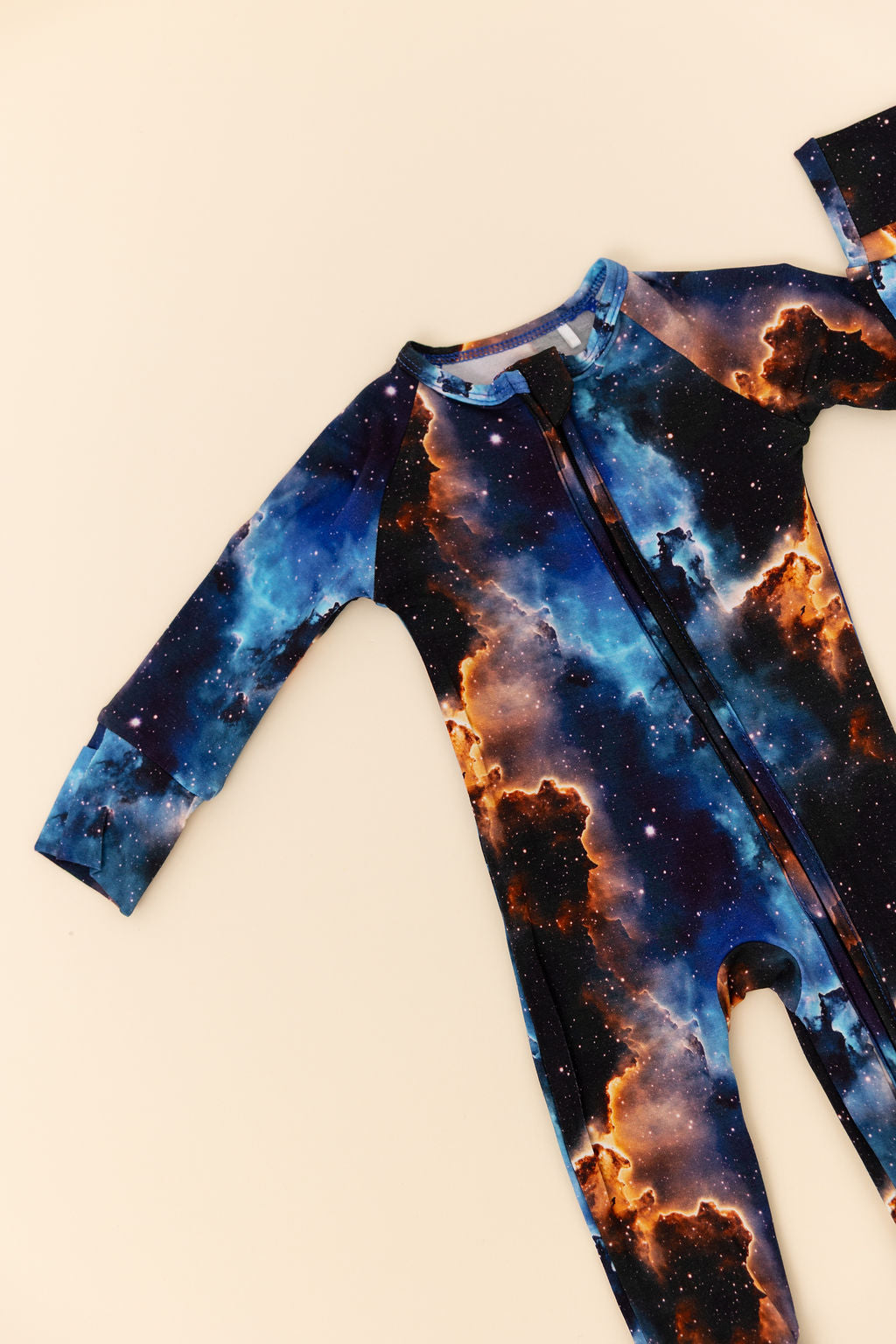 Baby wearing a galaxy-themed bamboo romper on a off white background