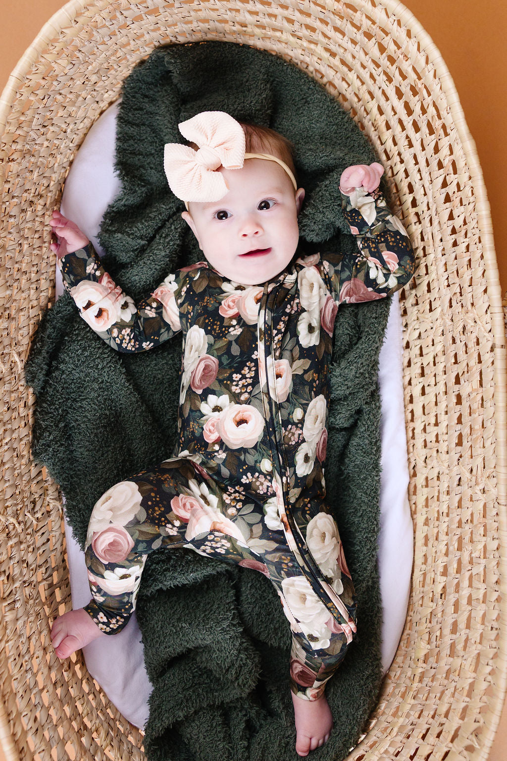 Reverie floral convertible bamboo romper with cream and blush flowers on a dark green background