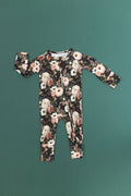 Reverie floral convertible bamboo romper with cream and blush flowers on a dark green background