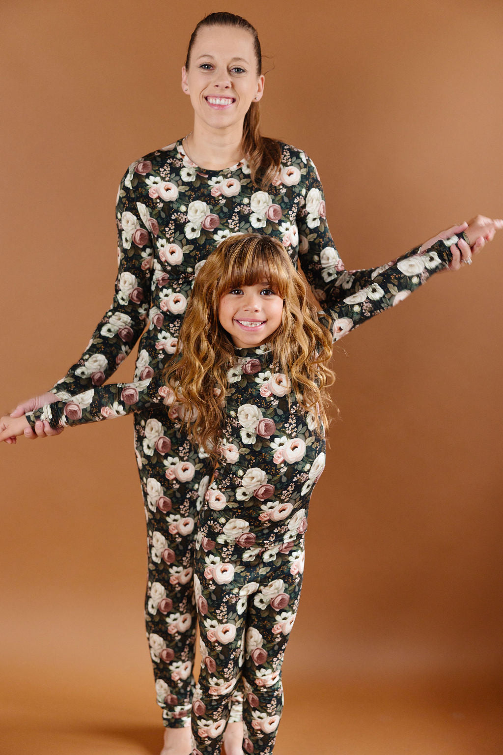 Reverie floral two-piece bamboo set with cream and blush flowers on a dark green background